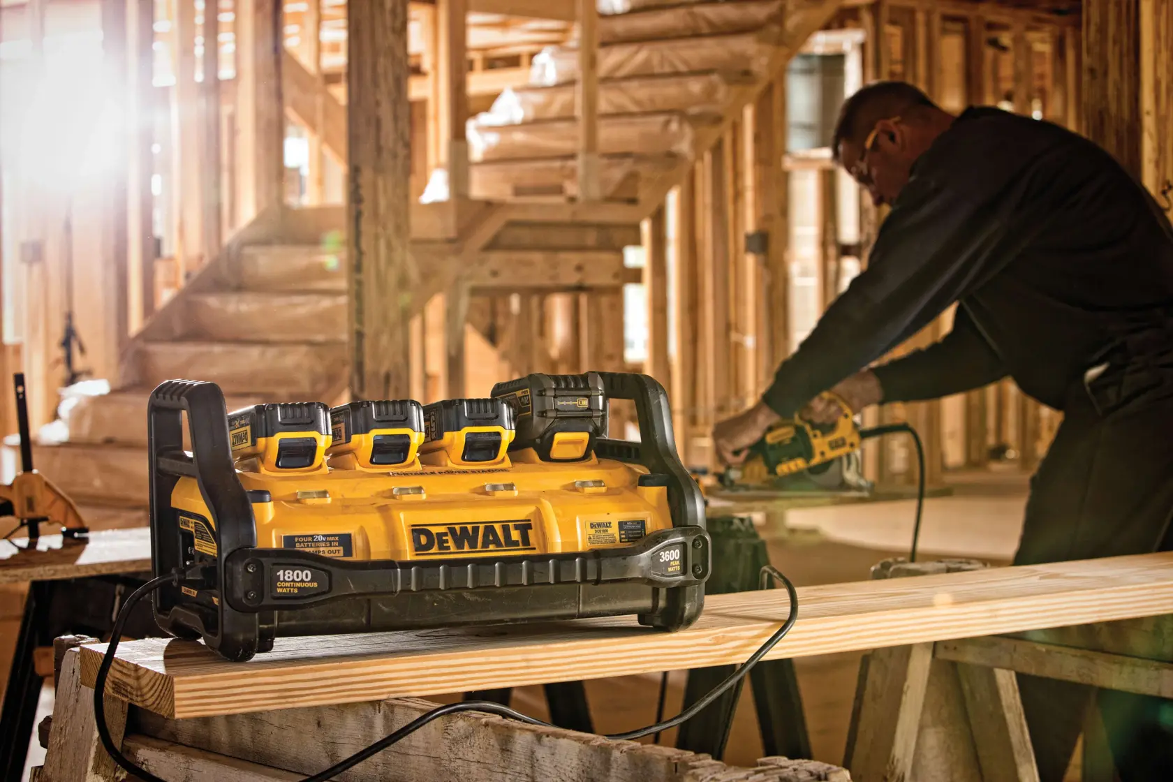 1800 Watt Portable Power Station and Battery Charger simultaneously charging four batteries and powering a construction tool