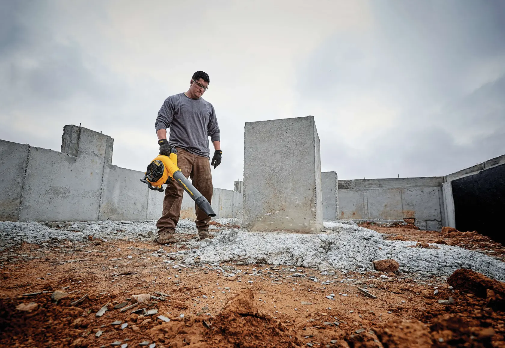 FLEXVOLT Handheld Blower being used by a worker to clear heavy jobsite debris on a rooftop
