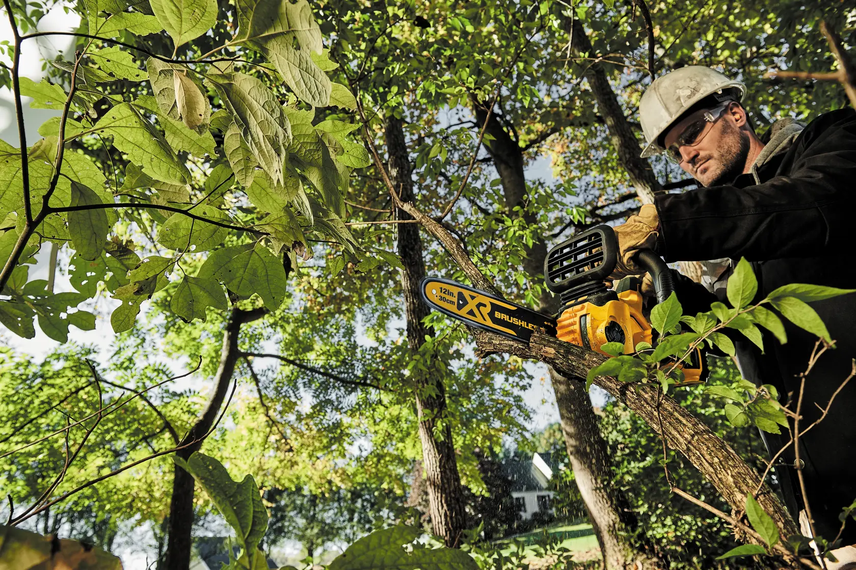 20 volt max x r compact 12 inch cordless chainsaw being used to cut a wooden plank by a person.