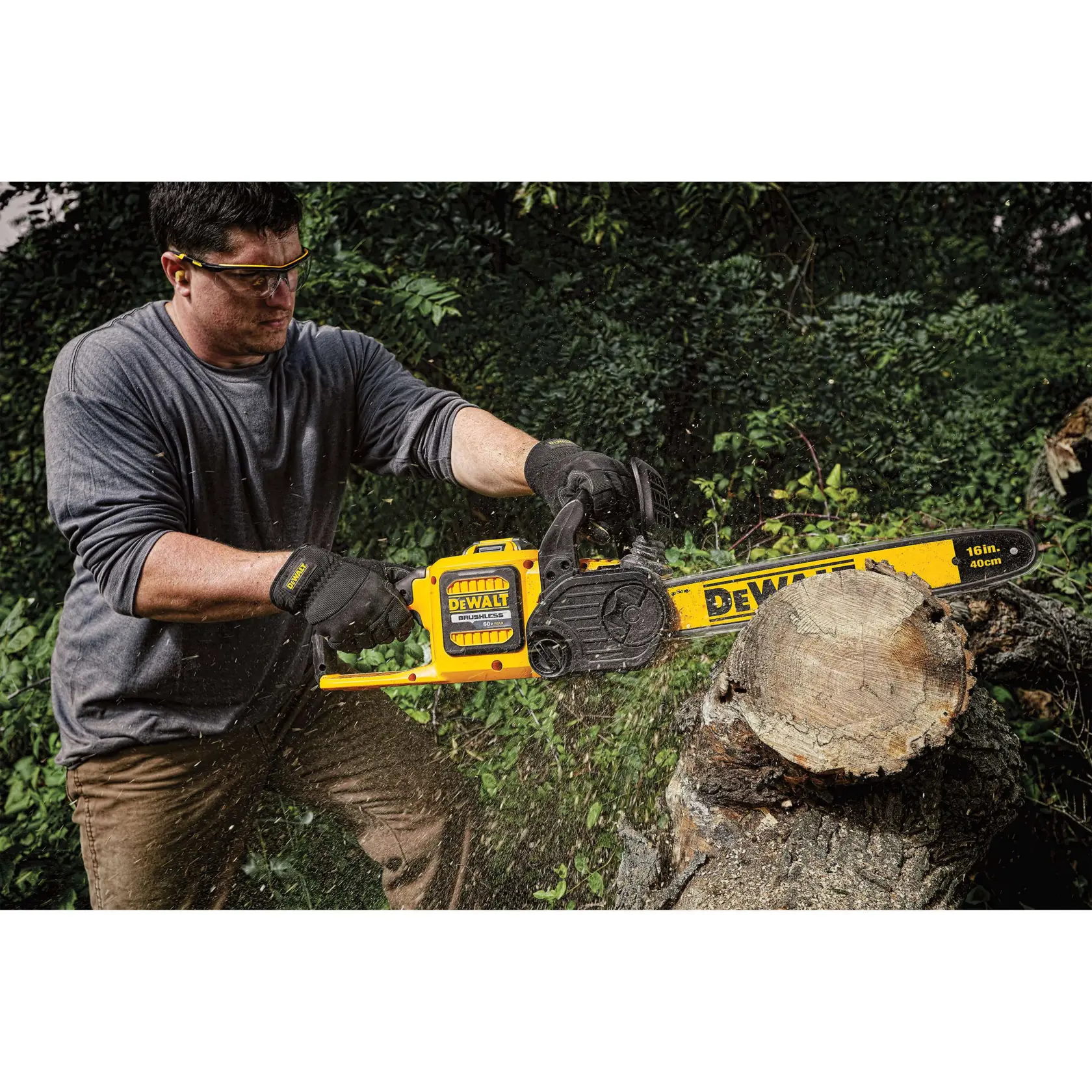 Cordless chainsaw being used saw through a log from a tree by a person.