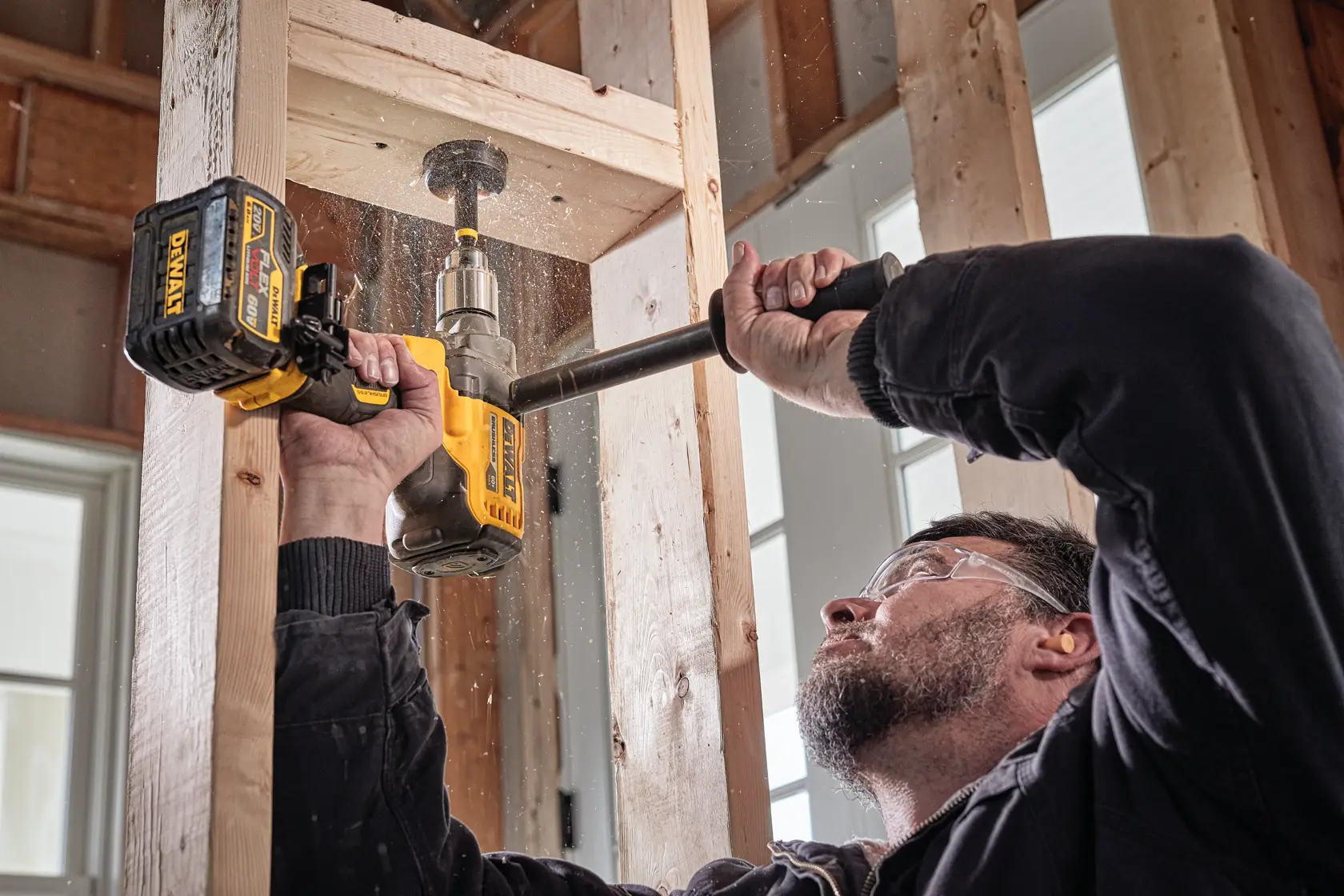 Mixer/Drill with E-Clutch® System being used by a worker to drill large holes in wooden planks at jobsite