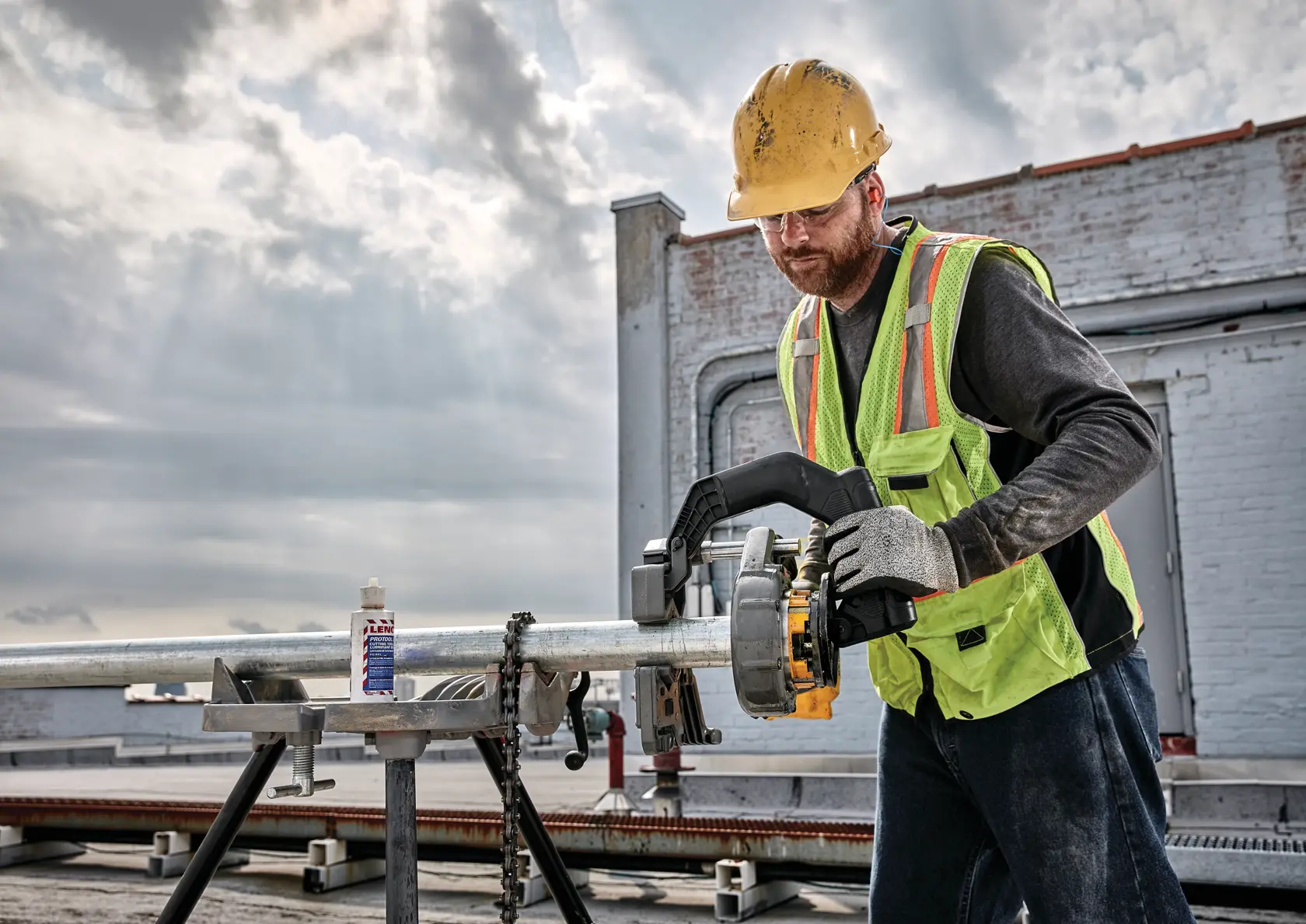 FLEXVOLT cordless pipe threader being used by person on steel pipe.