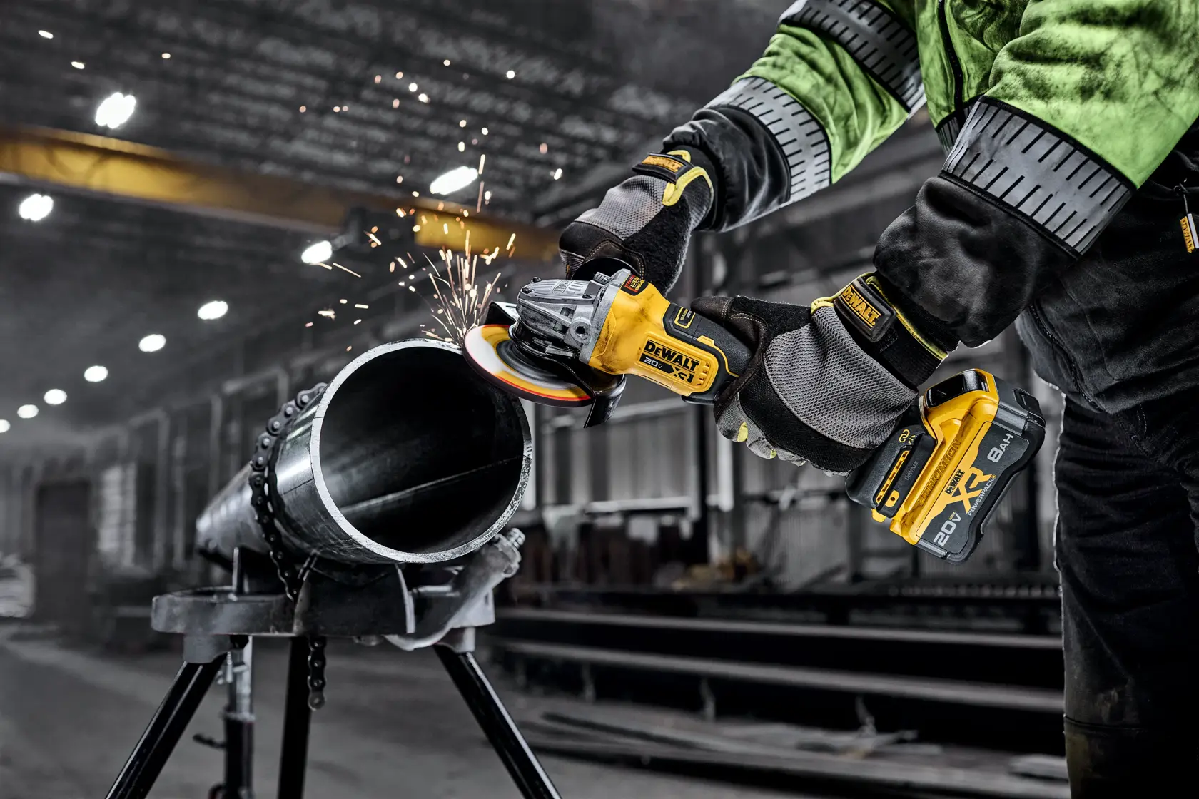 DEWALT 20V MAX* XR® 4-1/2 in. - 5 in. Angle Grinder grinding metal pipe in a commercial setting.