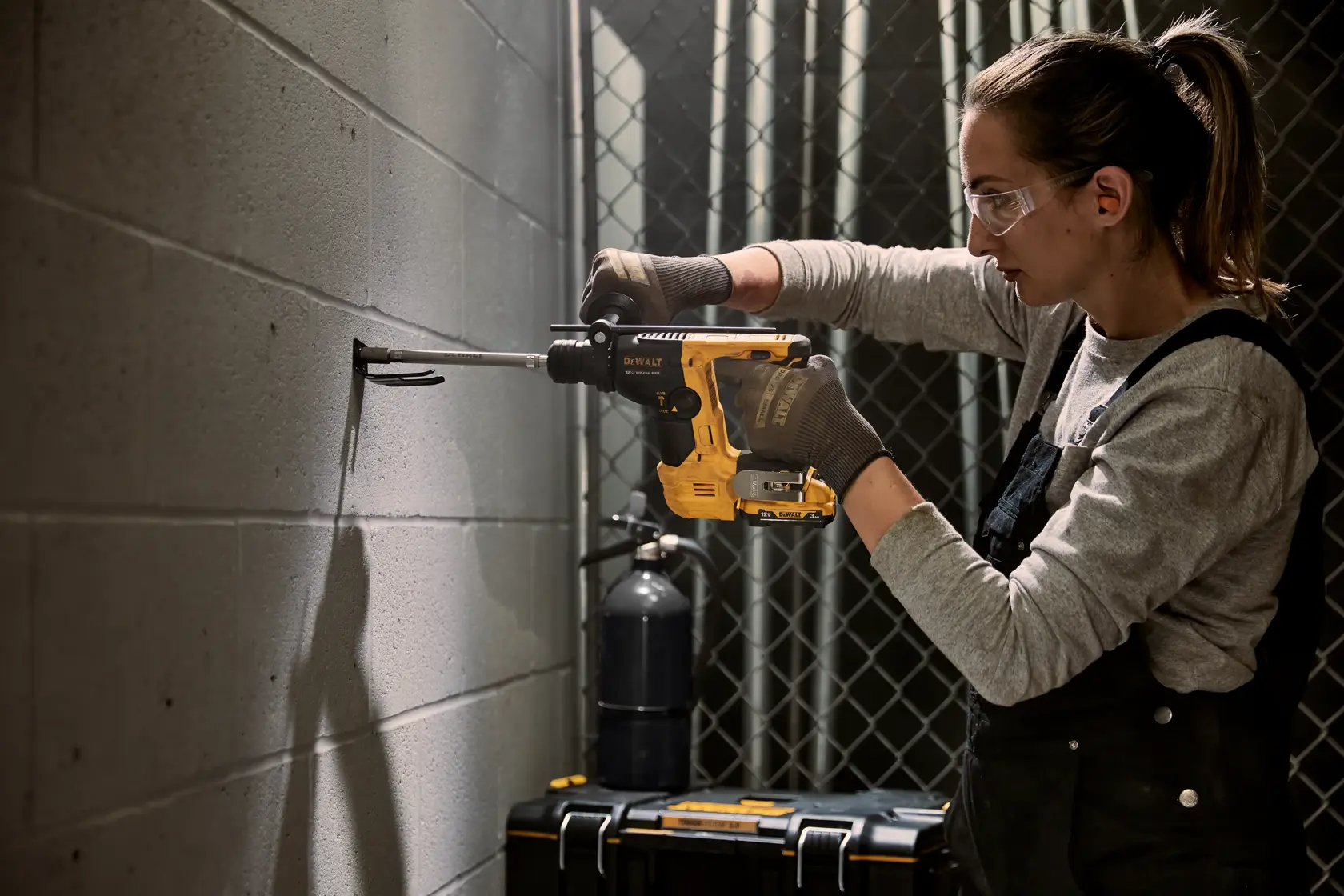 Brushless 9 sixteenth inch S D S PLUS Rotary Hammer Bare Tool being used for mounting hook on wall.