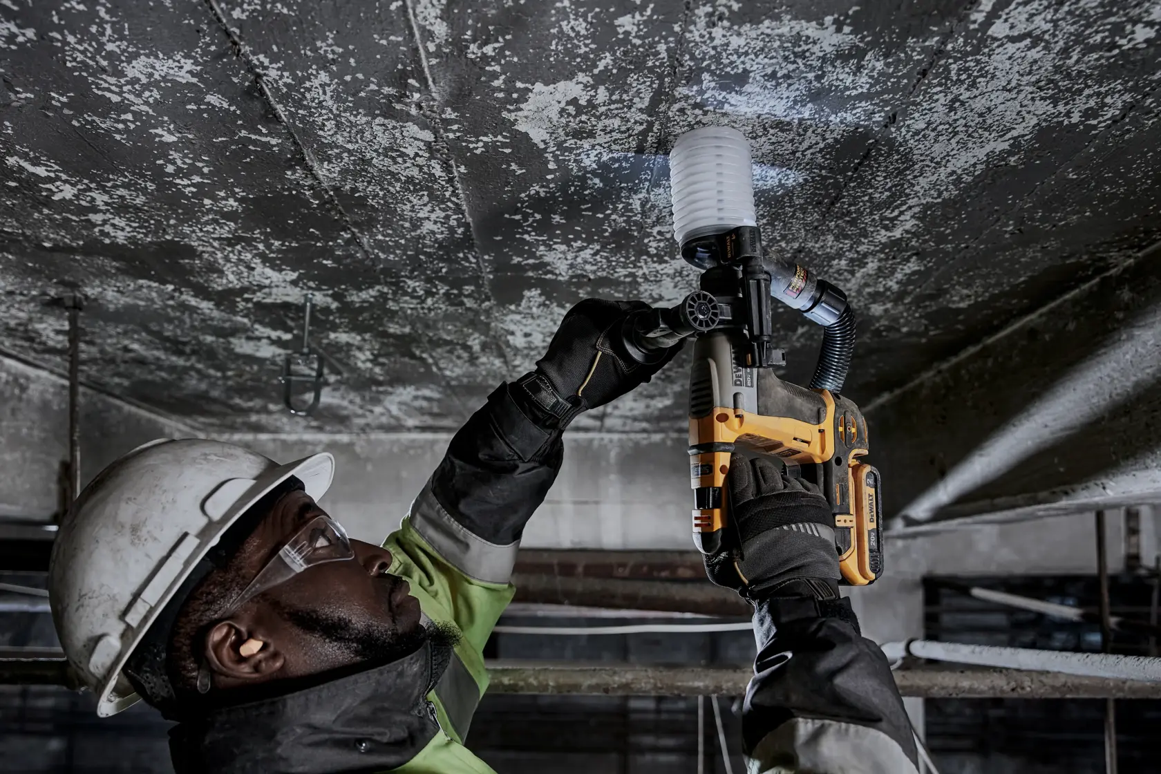 Atomic 20 volt five eighths inch brushless cordless S D S plus rotary hammer tool being used by a person.