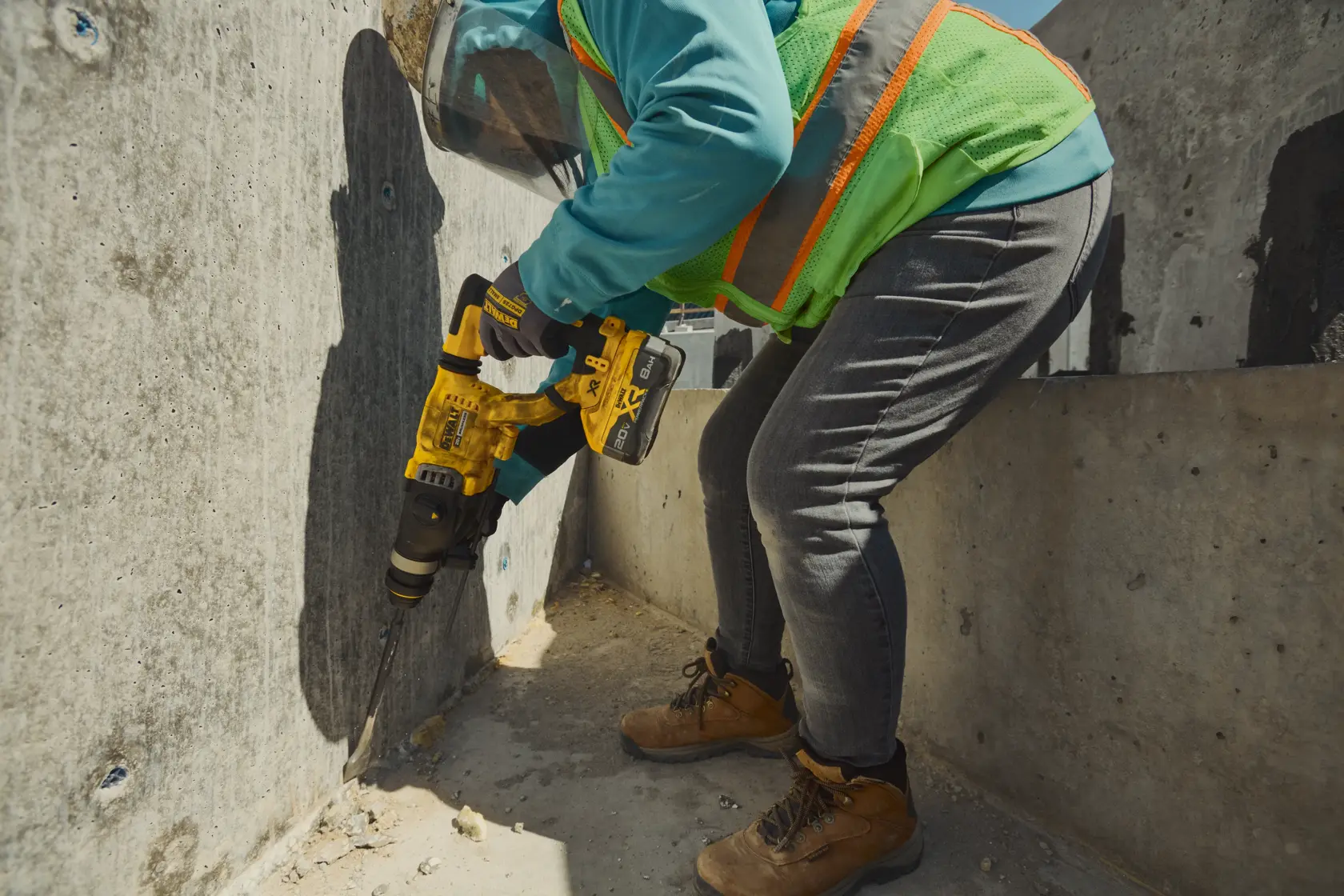 Brushless, cordless SDS PLUS D-Handle rotary hammer being used by a person