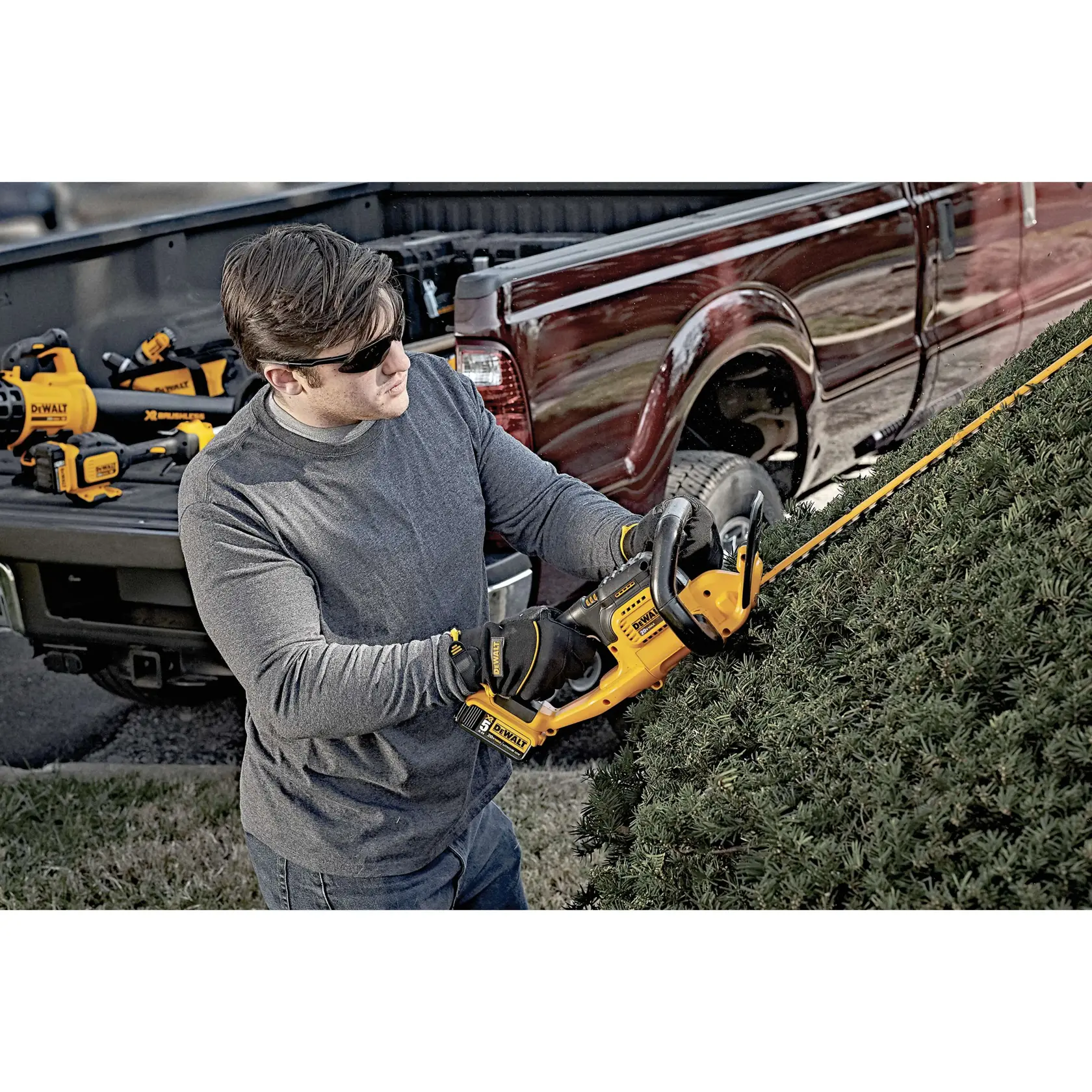 Lithium ion hedge trimmer being used by a person