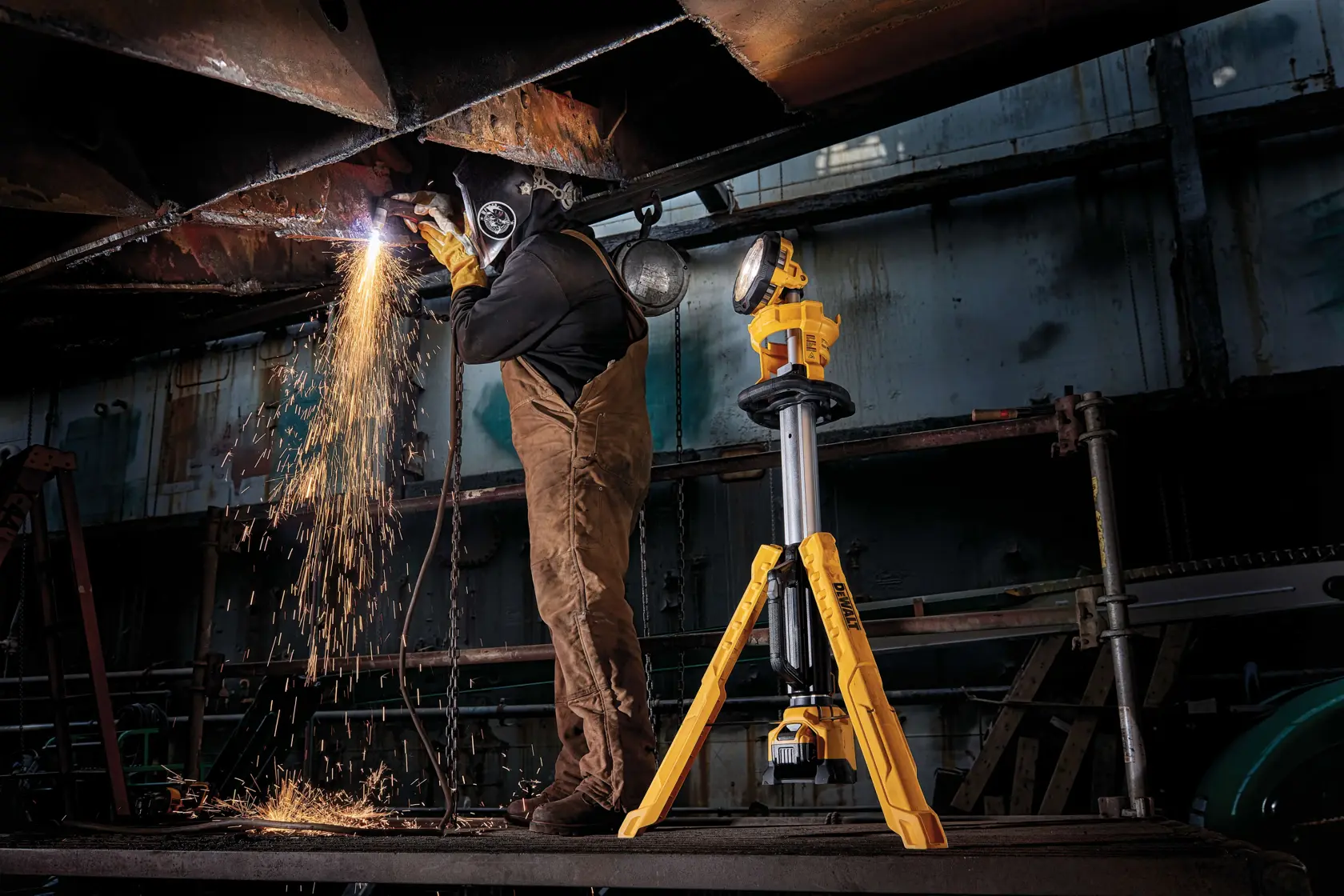 cordless tripod light being used by a person to cut metal