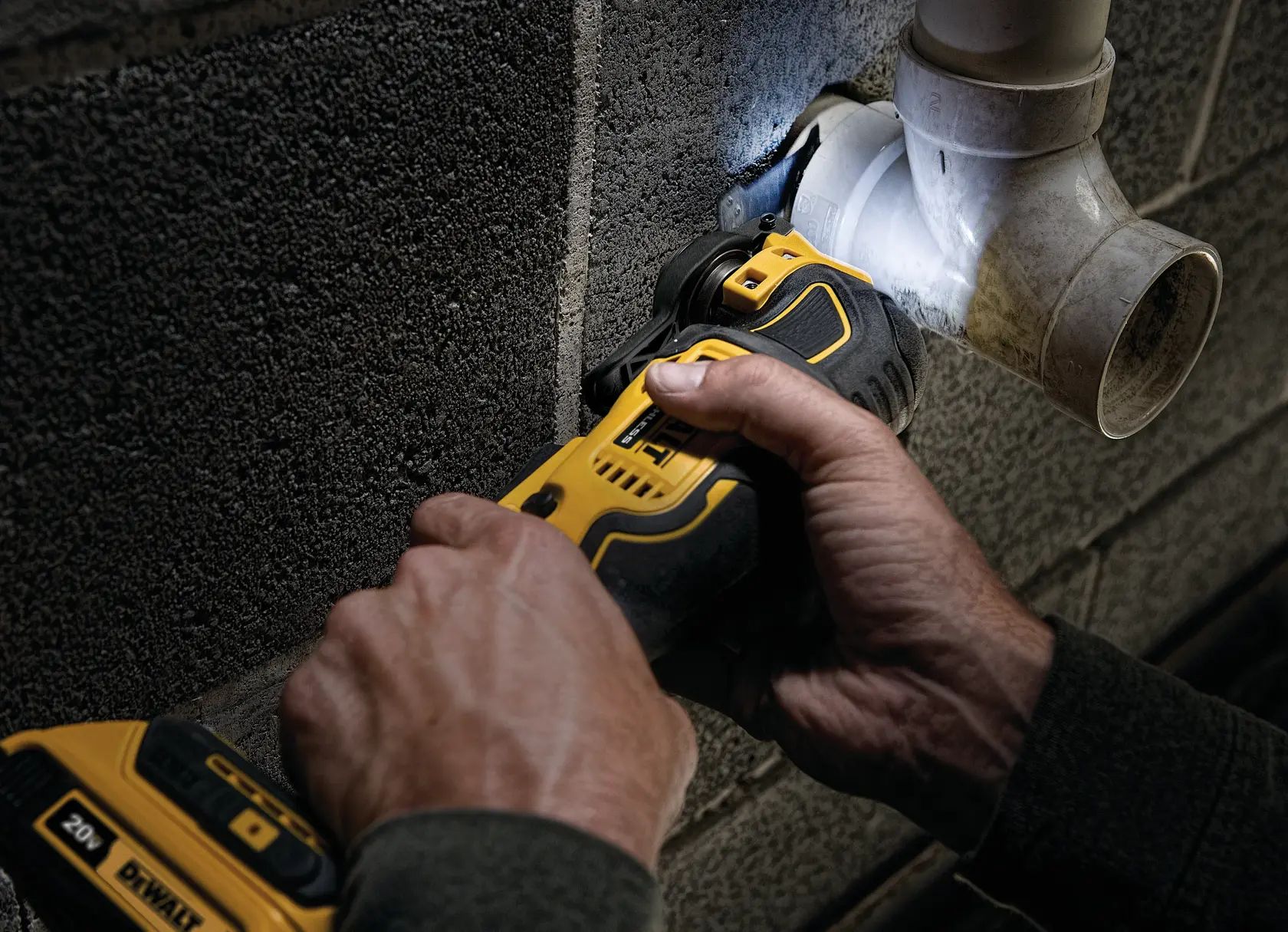 ATOMIC Brushless Cordless Oscillating Multi Tool being used by person to cut through a plumbing pipe