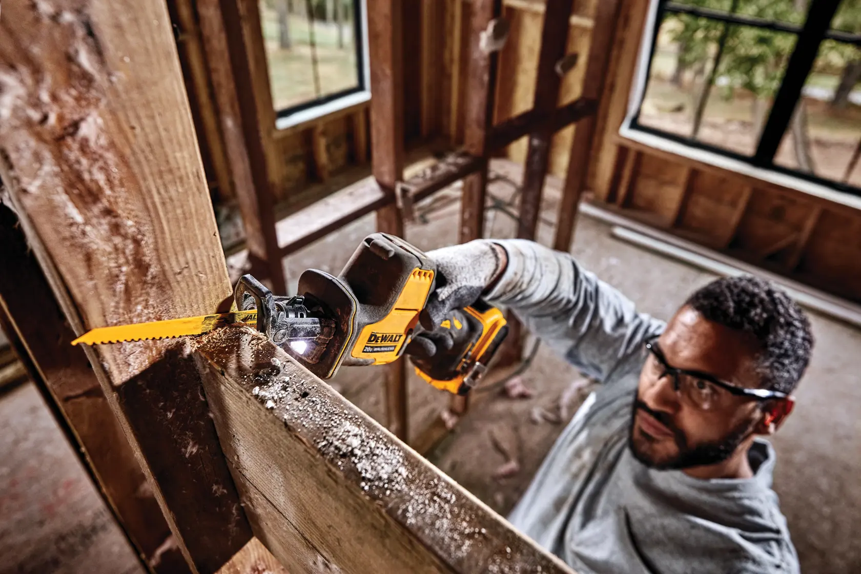 Overhead view of Cordless One Handed Reciprocating Saw being used by worker to cut through shiplap