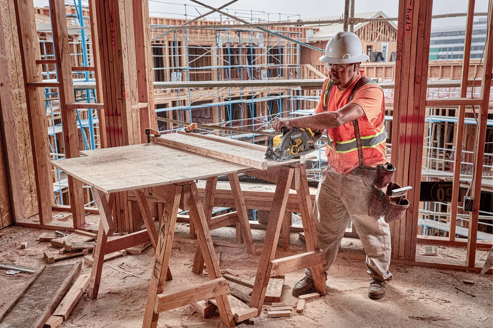 Over head view of FLEXVOLT cordless worm drive style saw being used by person to cut wood.