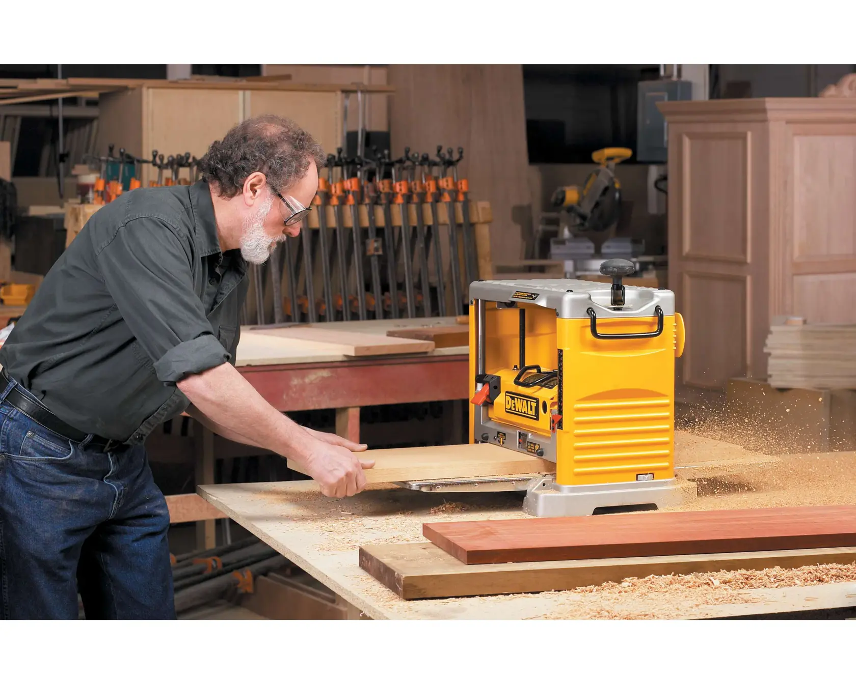 12 and half inch Thickness Planer with Three Knife Cutter Head being used by a person on wooden plank.