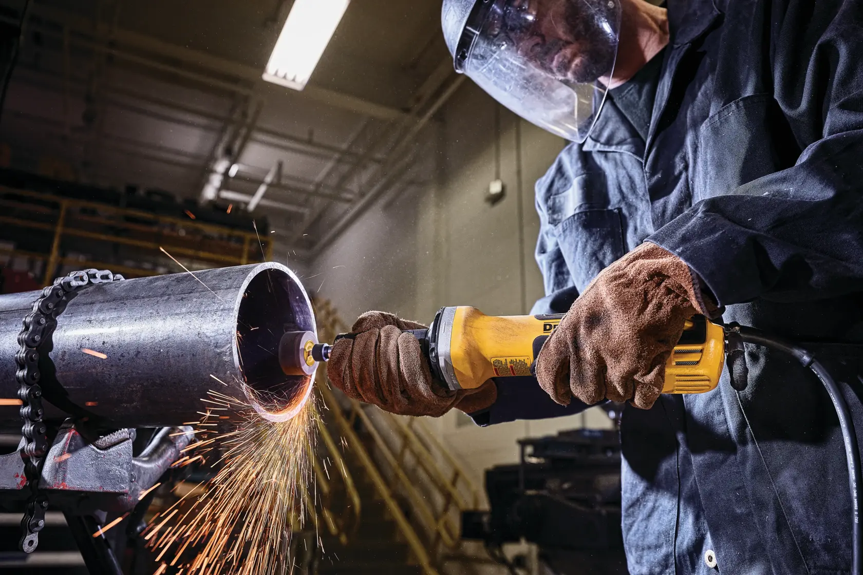 2 inch brushless variable speed paddle switch die grinder with nolock-on being used to grind on a metal pipe by a worker at a worksite.