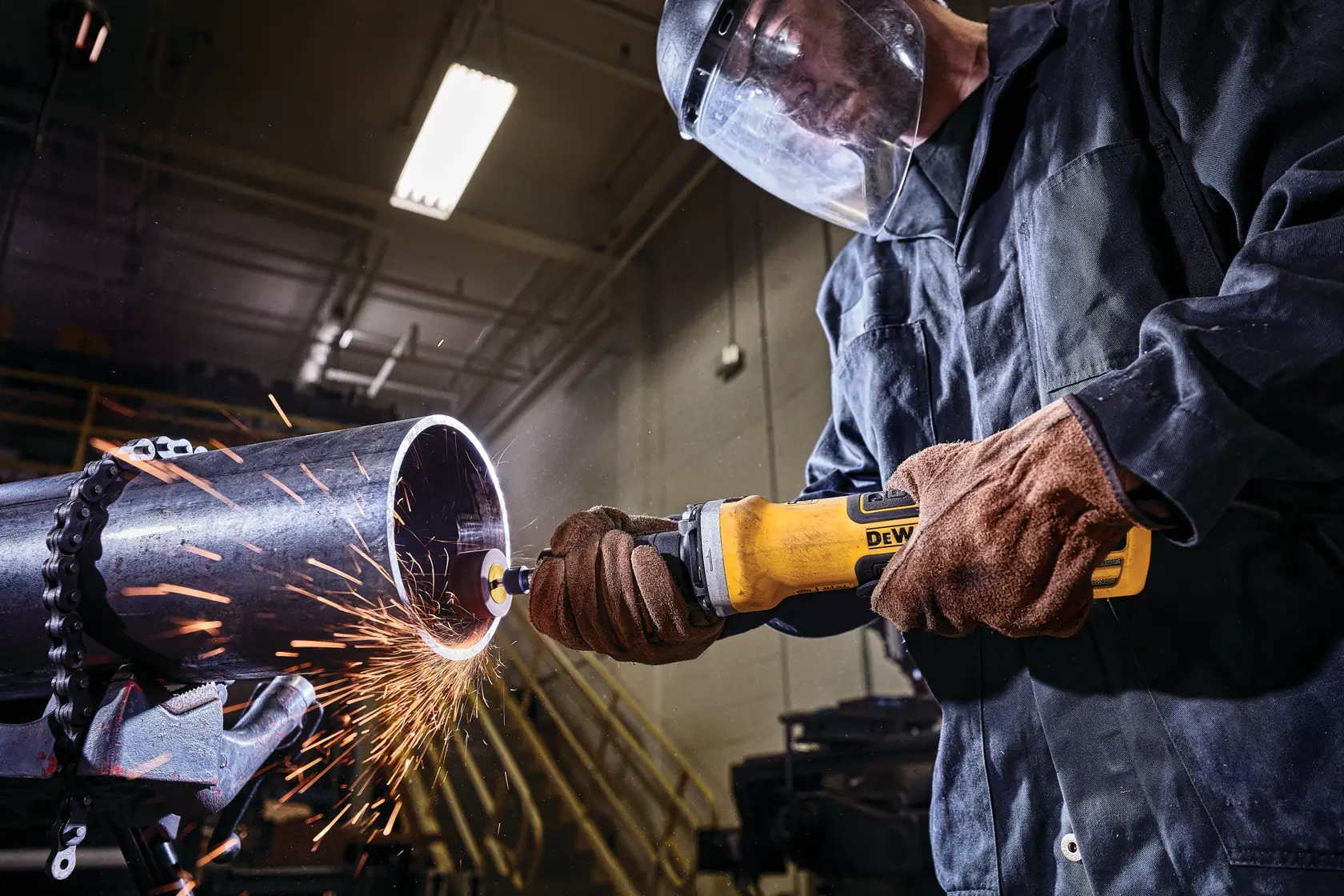 2 inch brushless variable speed paddle switch die grinder with lock-on being used to grind on opening of a metal pipe by a worker.