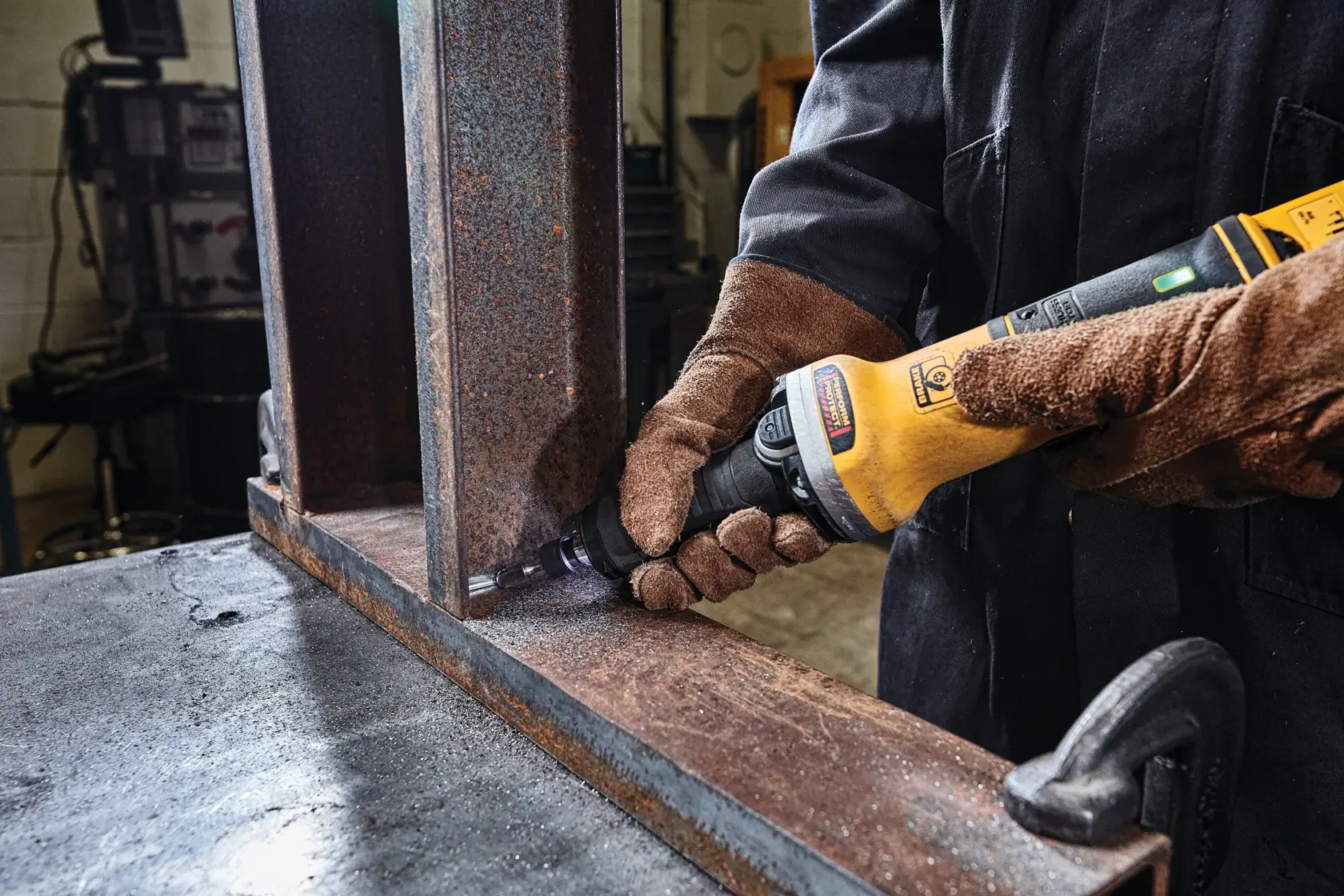 2 inch brushless variable speed paddle switch die grinder with lock-on grinding on a rusted metal structure.