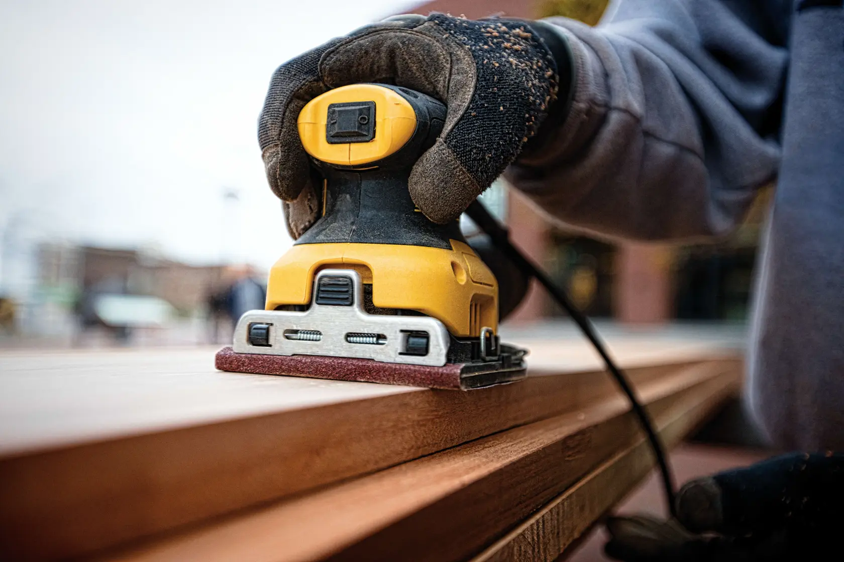 One quarter inch sheet palm grip sander sanding a wooden sheet.