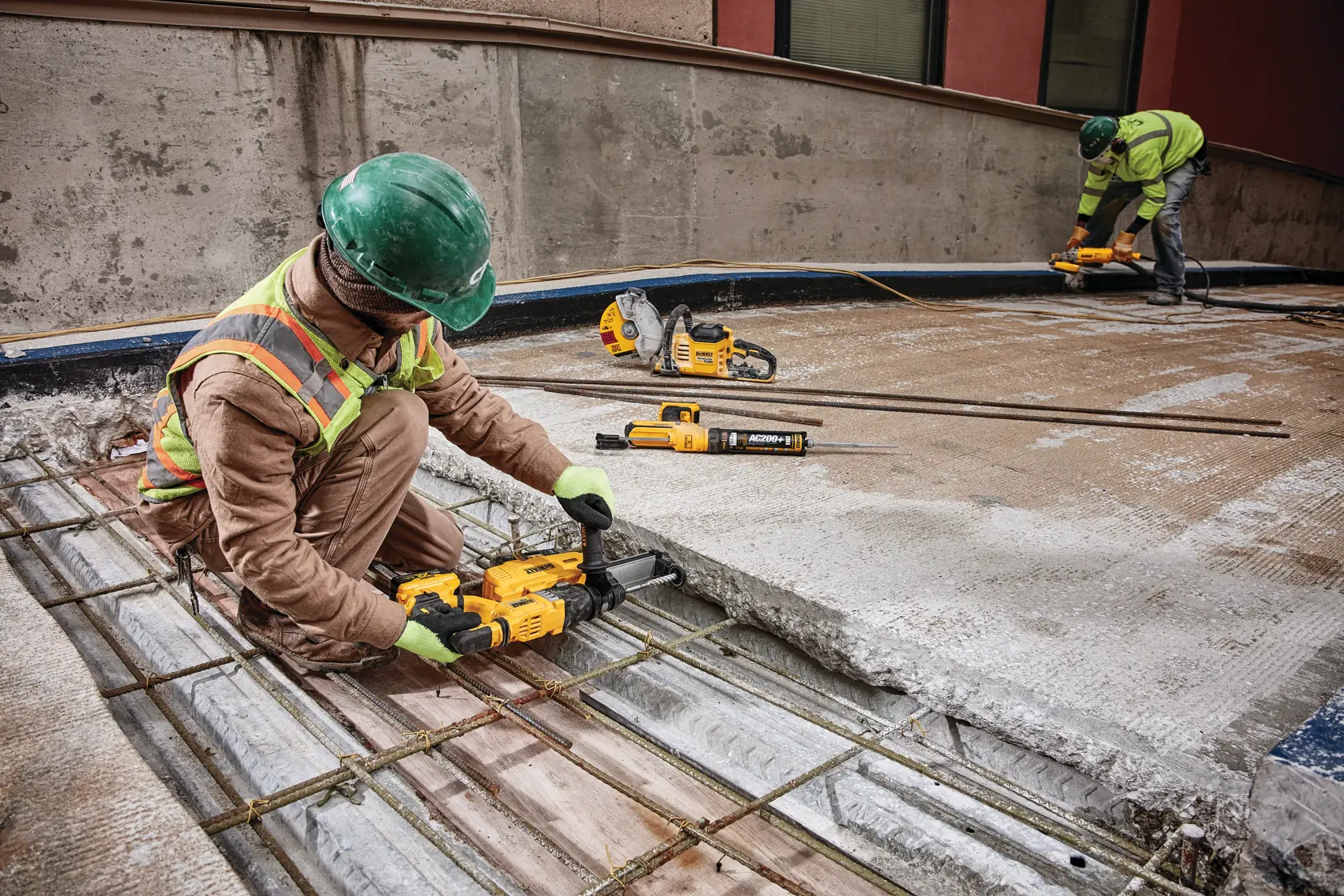 Dust extractor being used by a person to drill.
