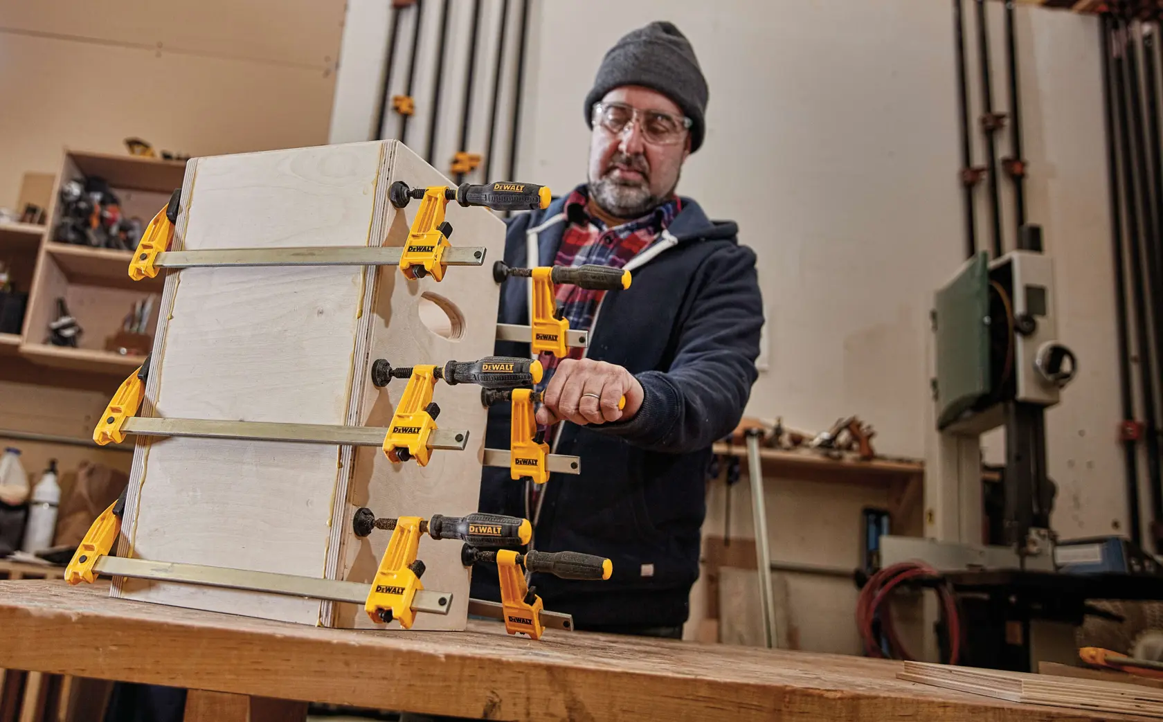 24 inch Bar Clamp being used on a wooden structure by a person in a workshop.
