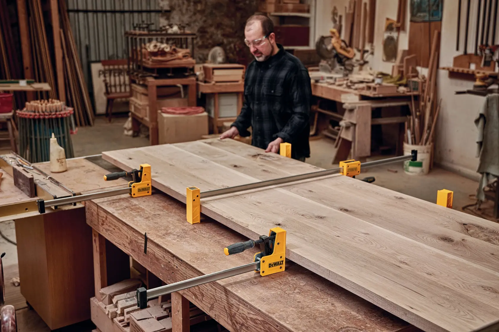48 inch Parallel Bar Clamp being used on a wooden structure by a person in a workshop.