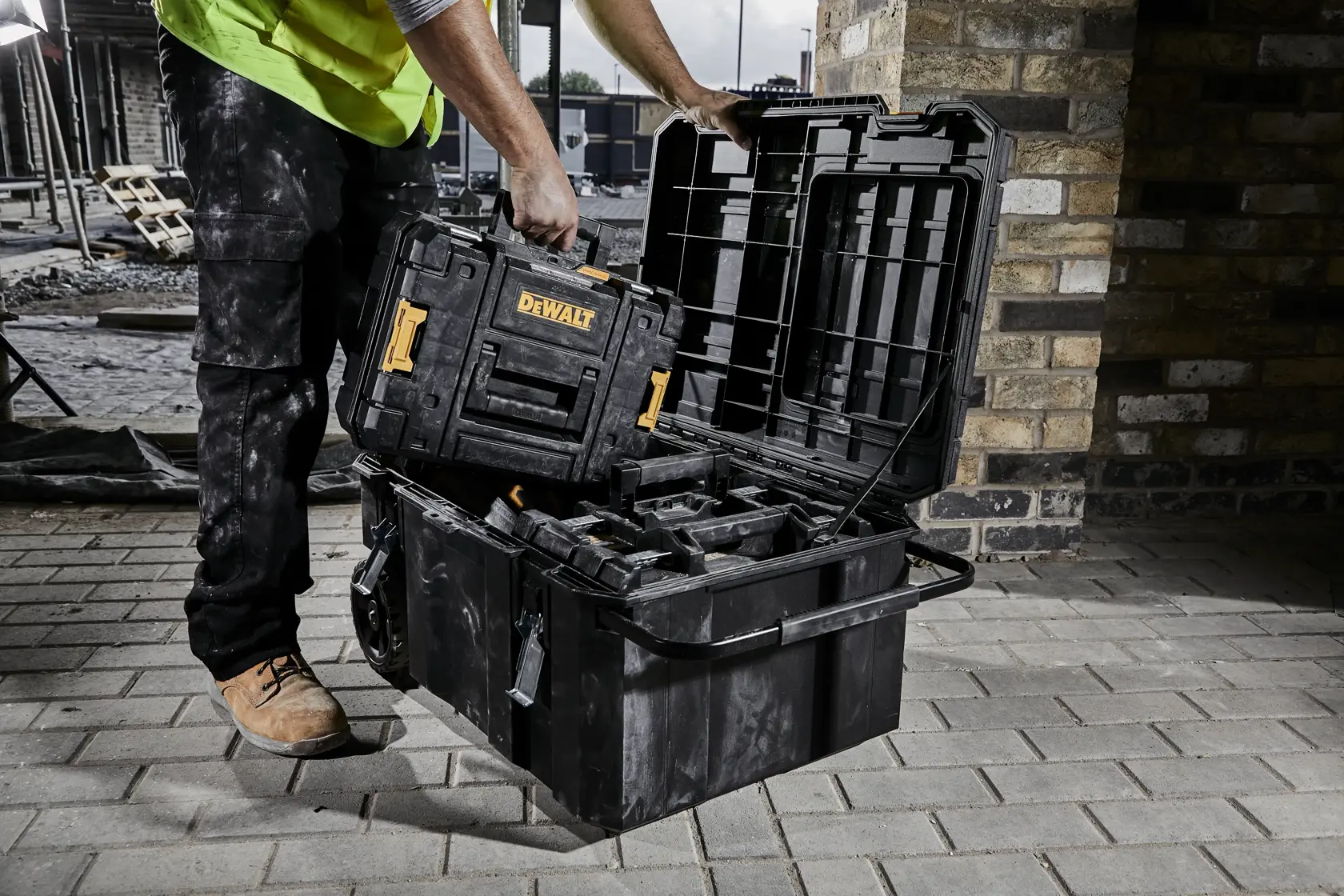 Construction worker pulling a TSTAK case from an open TSTAK job chest