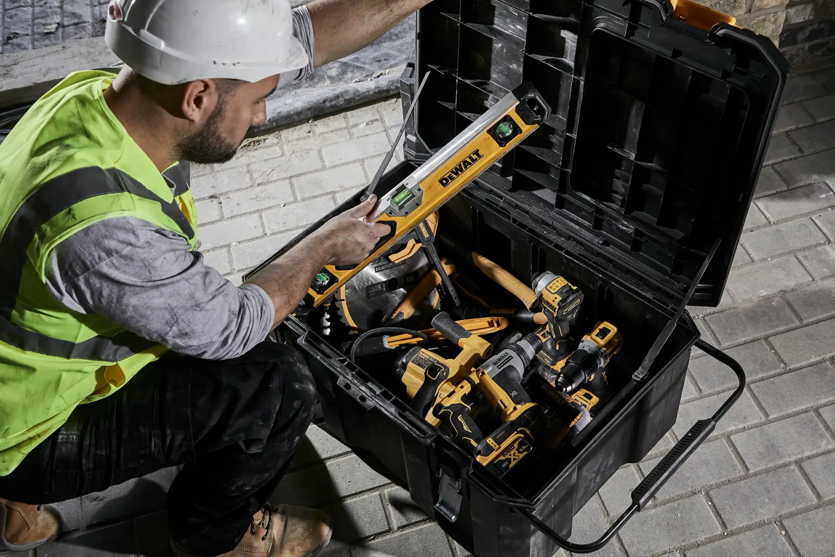 Construction worker pulling a box beam level from an open TSTAK job chest