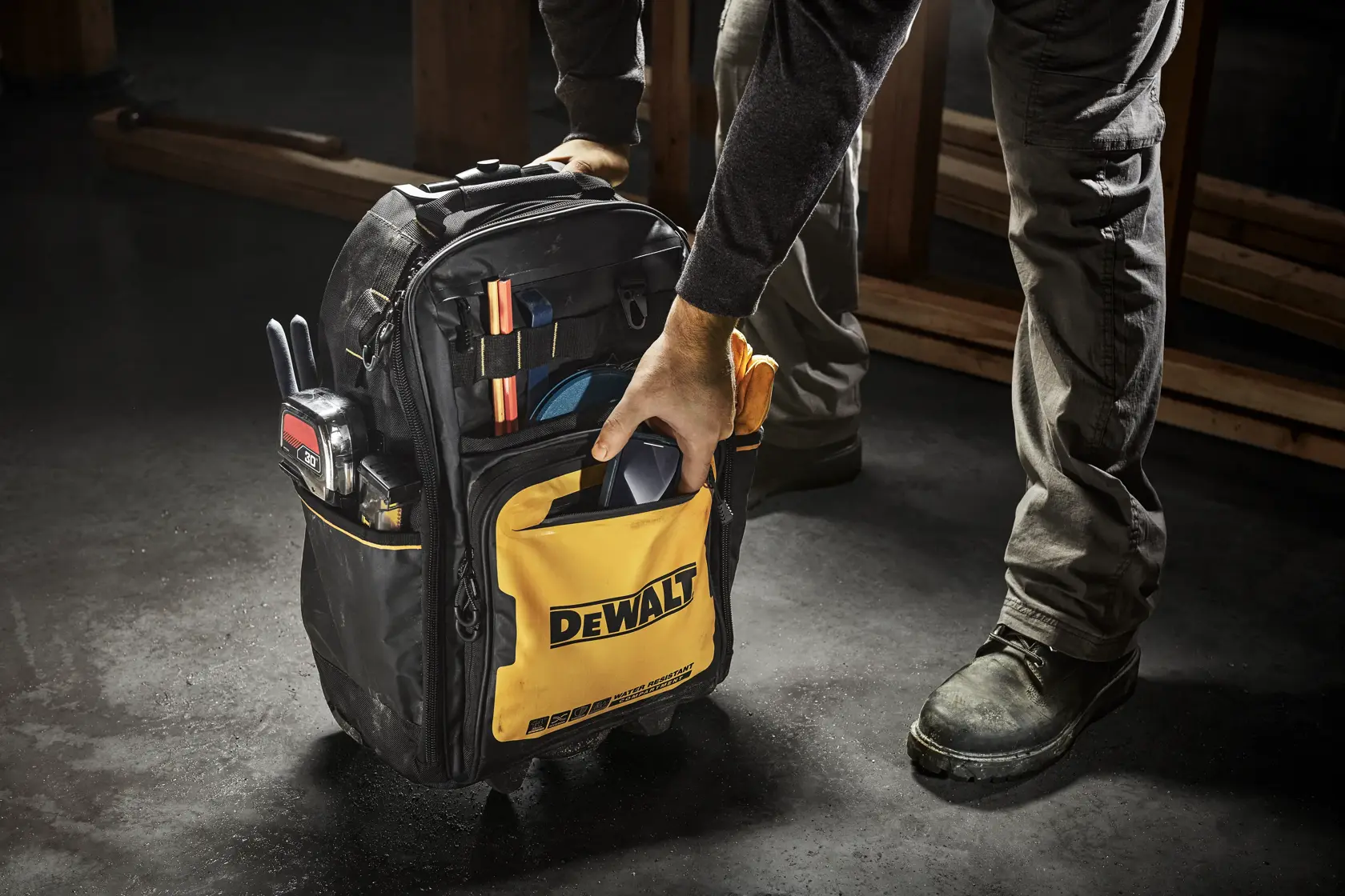CONSTRUCTION WORKER USING DEWALT PROFESSIONAL BACKPACK WITH WHEELS