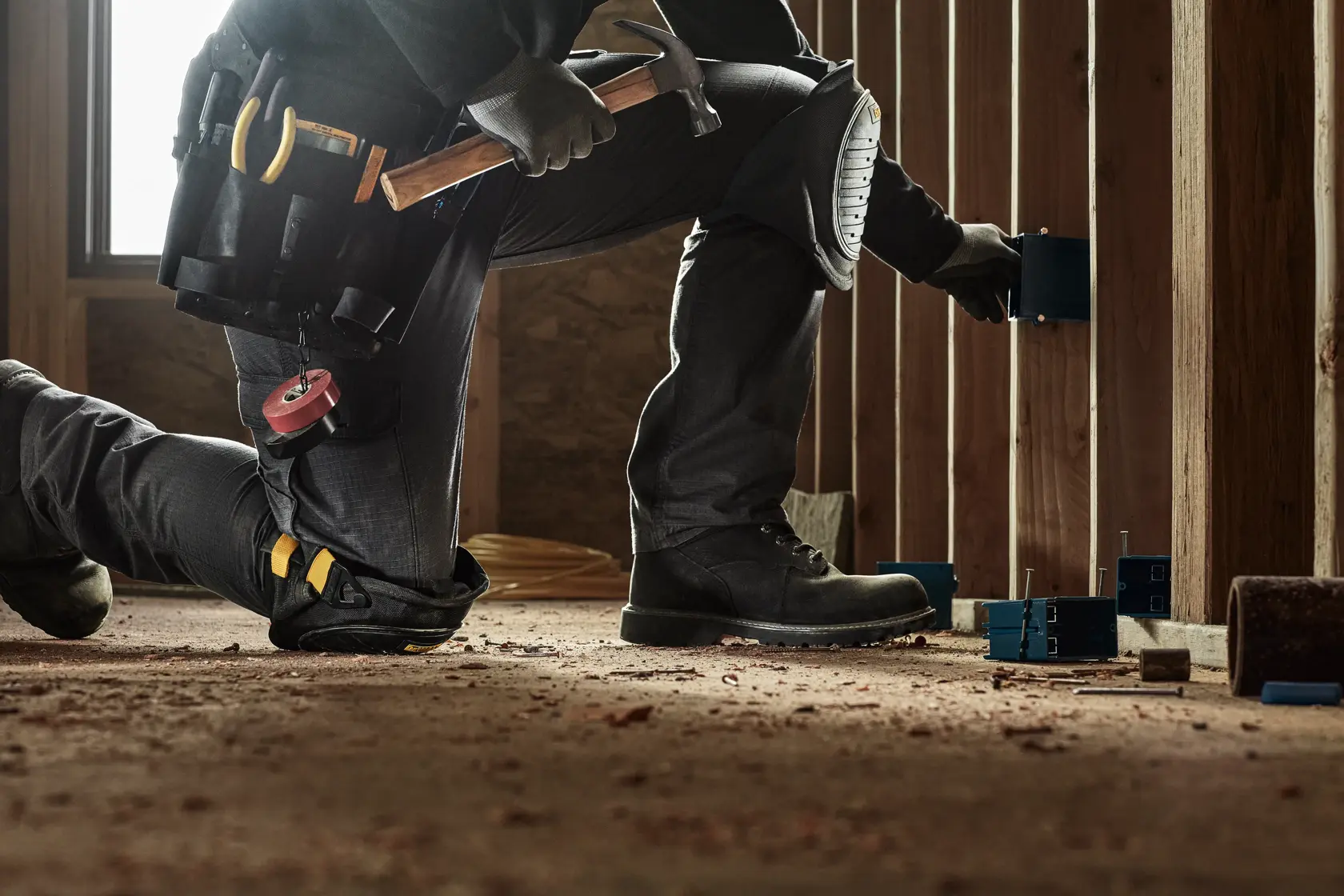 CONSTRUCTION PRO WEARING DEWALT HARD SHELL KNEE PADS WITH GEL