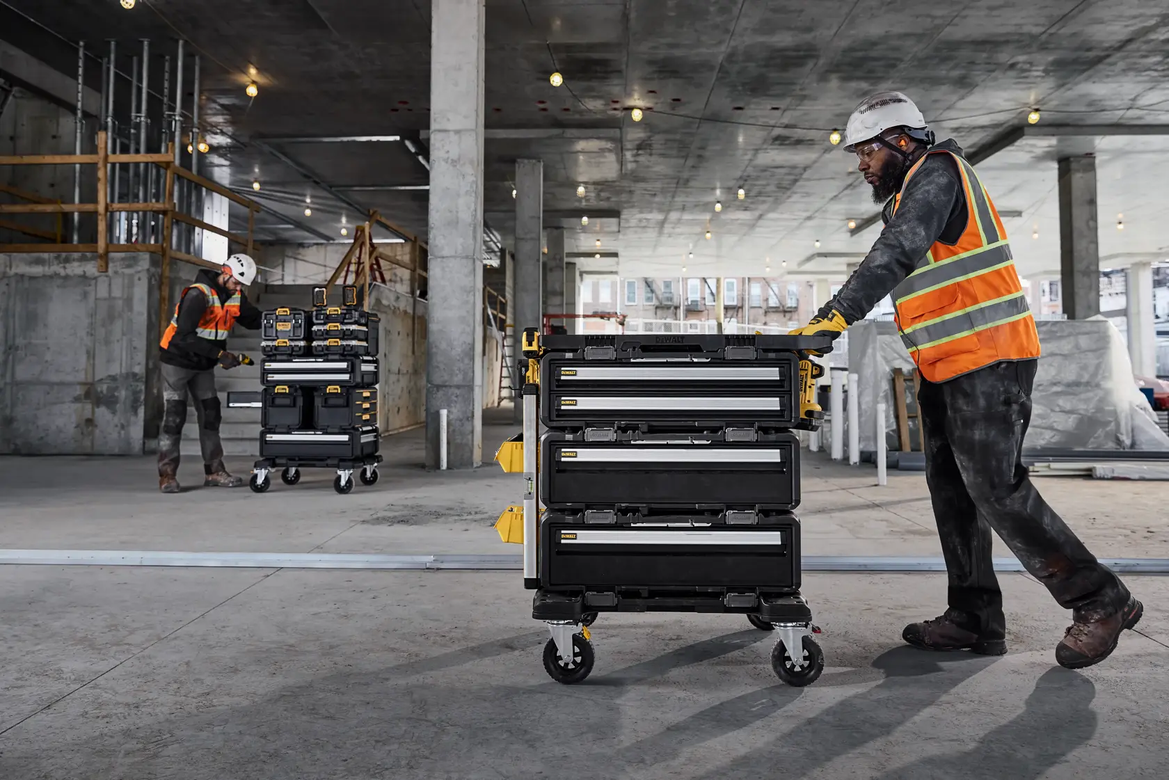 Soemone working on a TOUGHSYSTEM 2.0 tower and someone rolling a TOUGHSYSTEM 2.0 DXL 5-in-1 tower in a commercial enviornment